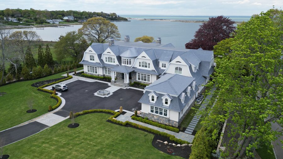 Waterfront shingle house with slate-look dormers and a wide asphalt motor court